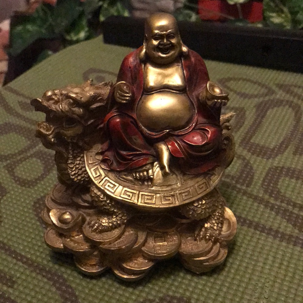 Ceramic Fat Buddha on the celestial creature. New